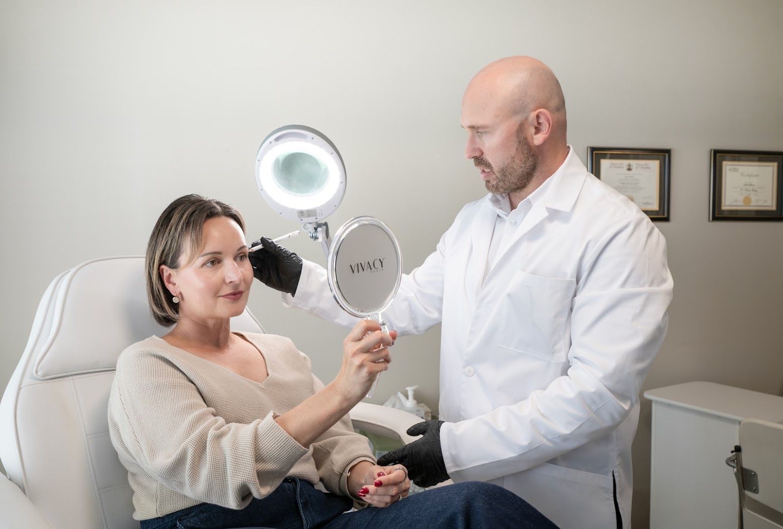 Mark reviewing a client's expression lines with her in a hand mirror during a facial assessment