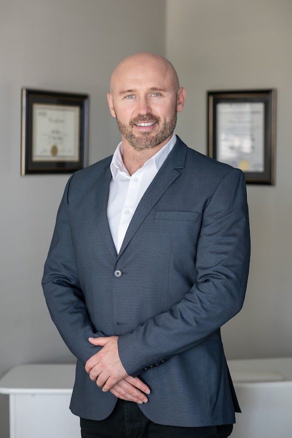 Mark in a navy suit standing in the clinic