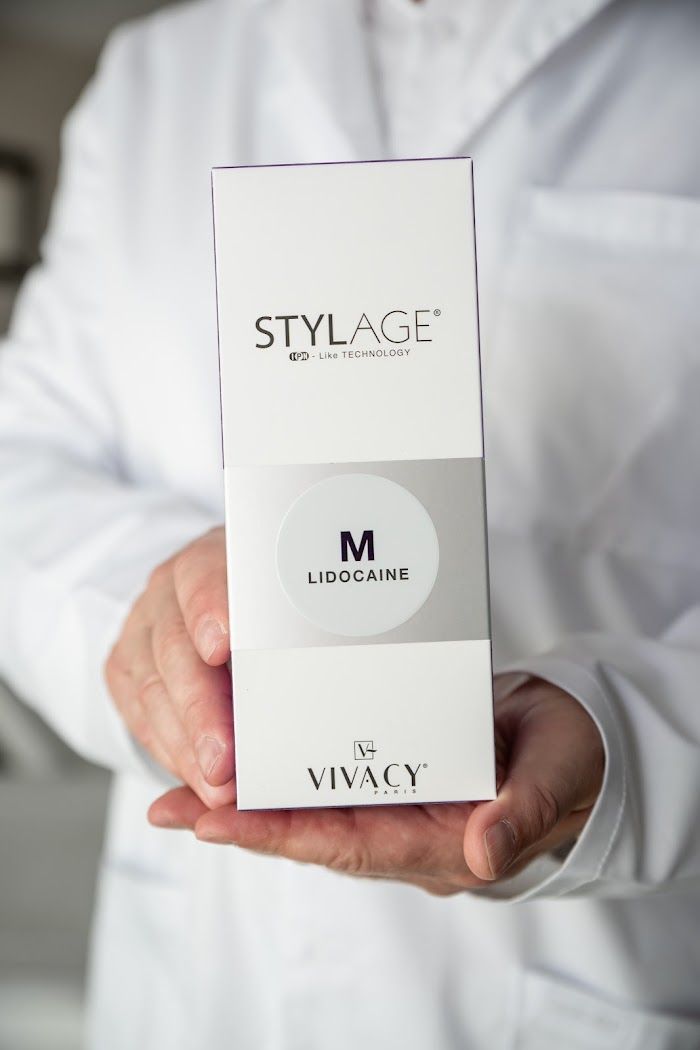 Mark holding a box of Stylage M hyaluronic acid filler with lidocaine